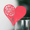 Macro detail of red heart laser-cut wine glass card for wedding table decorations - Pearlescent Red