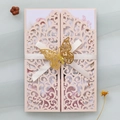 Λεπτομέρεια ροζ προσκλητηρίου γάμου laser-cut με χρυσή πεταλούδα και λευκή σατέν κορδέλα - Ροζ της Σάρκας