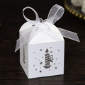 Close-up of white laser-cut Christmas gift box with candle pattern and organza bow - White