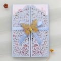 Λεπτομέρεια γαλάζιας κάρτας πρόσκλησης laser-cut με χρυσή πεταλούδα και κορδέλα - Γαλάζιο της Ομίχλης
