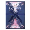 Macro detail of navy laser-cut invitation with intricate vine patterns and a silk ribbon bow - Magic Blue
