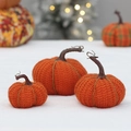 Trois citrouilles tricotées orange de tailles variées avec tiges sur de la fausse fourrure - Style Lot (QD22B505)