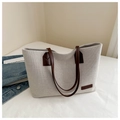 Detail of minimalist cream canvas tote bag with brown leather handles and fashion patch - Coffee