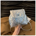 Détail d'un sac à dos matelassé argenté avec bandoulière chaîne et fermoir pivotant - Argenté