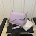 Lavendel paarse crossbody tas met gegolfde flap en ketting in stijlvolle lifestyle setting - Paars