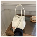 Minimalistische cremeweiße Beuteltasche mit Kieseltextur und verstellbarem Schultergurt - Weiß