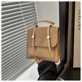 Detalle de la mochila de cuero caqui claro que muestra textura y asa de mano superior - Caqui