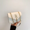 Borsa a tracolla bianca trapuntata con logo SS dorato e tracolla a catena tenuta da una persona - Bianco