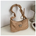 Close-up of khaki shoulder bag featuring silver butterfly buckle and pleated texture handle - Khaki