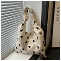 Dettaglio di una borsa tote beige con stampe a cuore nero e consistenza setosa - Stile Stampato Cuore Nero / Cuore