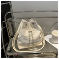 Detail of a beige drawstring bucket bag featuring a silk-like texture and metal chain - White