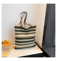 Detailed texture of a large striped woven tote bag with brown leather shoulder straps - Brown