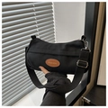 Detalle del bolso bandolera de lona negra con parche de cuero y correa ajustable - Negro