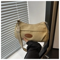 Detalle de bolso bandolera de lona caqui con correa ajustable y parche de moda ovalado - Caqui