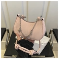 Detalle del bolso hobo rosa con textura de cuero fruncido, cadena y dijes de corazón - Rosa