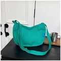 Vue détaillée du sac hobo en toile verte avec poches avant et bandoulière réglable - Bleu sans pendentif