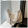 Close-up of white tote bag with textured ruched fabric and braided rope zipper detail - White
