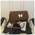Detail of a brown shoulder bag featuring pleated faux leather and a silver butterfly buckle - Coffee