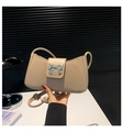 Detalle del bolso de hombro de PU beige con hebilla de mariposa plateada y correa con nudos - Caqui
