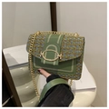 Détail d'un sac bandoulière en tweed vert avec chaîne dorée et boucle métallique - Vert