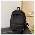 Detail of minimalist black canvas backpack with drawstring side pockets and fashion label - Black