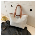 Bolso tote minimalista de lona crema con correas de cuero marrón en un entorno de estilo - Marrón