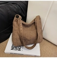 Bolso tote de pana marrón con correa ajustable sobre libros blancos de estilo urbano - Marrón