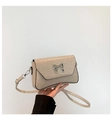 Détail du sac à paillettes avec boucle papillon argentée et bordure noire élégante - Doré