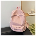 Pale pink minimalist nylon backpack on a sofa with cozy room decor in the background - Pink