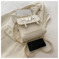 Detalle de mini mochila crema con adorno de mariposa plateada y remaches de base - Blanco