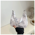 Nahaufnahme der weißen Handtasche mit Schmetterlings-Sternen-Muster im minimalistischen Stil - Silber
