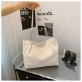 Chic cream white pleated tote bag with silver chain strap shown in a modern interior setting - Beige