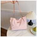 Pink pleated tote bag with silver chain strap shown in a stylish minimalist setting - Pink