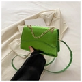 Sac bandoulière vert brillant aspect crocodile avec chaîne dorée sur un blazer blanc - Vert