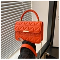 Detail van oranje gewatteerde tas met gevlochten handvat en gouden kettingriem - Oranje