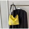 Detail of yellow shoulder bag featuring floral embroidery and textured pattern - Yellow