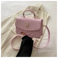 Elegant pink crossbody bag with metal butterfly accent and quilted triangle texture - Pink