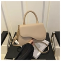 Beige crossbody bag with woven handle and magnetic flap closure on a black chair - Khaki