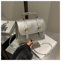 Detail of silver textured handbag with golden ring buckles and top handle - Silver