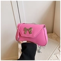 Pink crossbody bag with a silver bow and curved base, featuring a metal chain strap - Pink