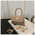 Detail of a beige PU leather crossbody bag with white bow hardware and gold chain strap - Khaki
