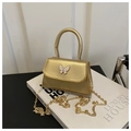 Detail view of the shimmering gold mini bag with a white butterfly ornament and chain strap - Gold