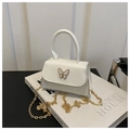 Detail of white PU leather mini flap bag with golden butterfly buckle and chain strap - White