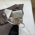 Kleine silberne Umhängetasche in Faltenoptik mit Logo und Plüsch-Anhänger - Silber