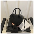Detalle del bolso con forma de corazón, textura de cocodrilo y cremalleras doradas - Negro
