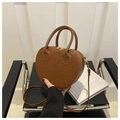 Detail of caramel brown heart-shaped bag with crocodile pattern and golden hardware - Brown