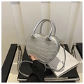 Primer plano del bolso plateado en forma de corazón con textura de cocodrilo premium - Plateado