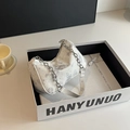 Nahaufnahme der weißen Segeltuchtasche mit Schmetterlingsdruck und Silberkette in Geschenkbox - Grau