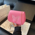 Vue détaillée du sac en cuir rose avec broderie papillon blanche et chaîne dorée - Rose