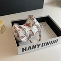 Vue détaillée du sac sous le bras à motif papillon blanc dans son coffret cadeau - Rouge